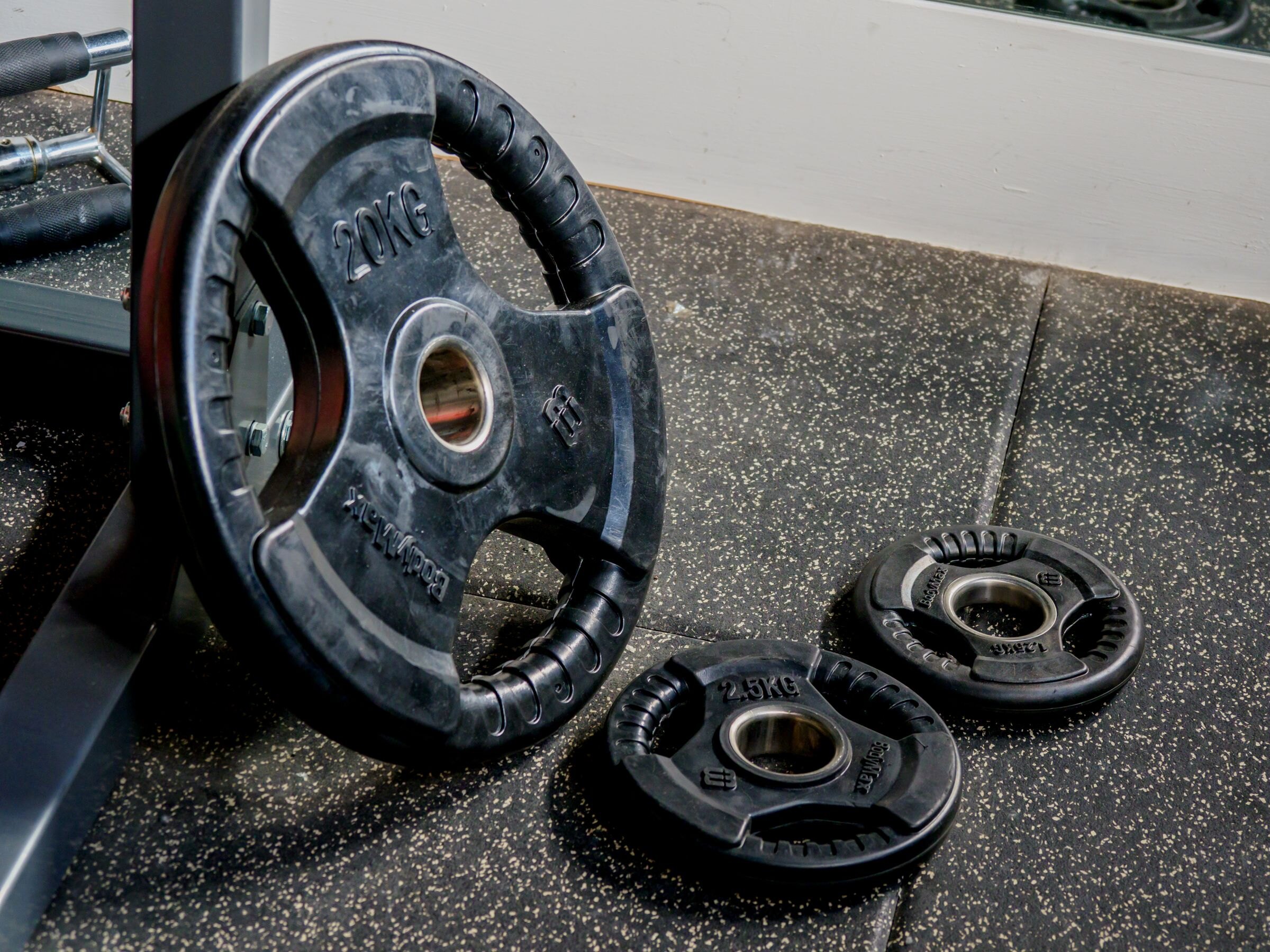 Weight plates of different sizes on a gym floor
